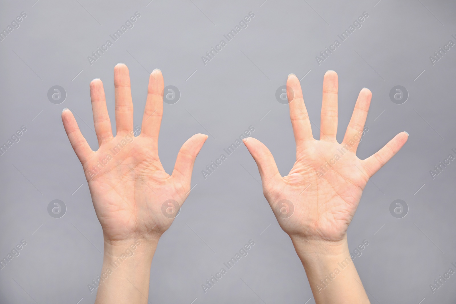 Photo of Woman showing sign ten on grey background, closeup. Body language