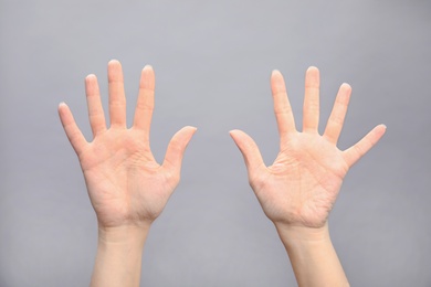 Photo of Woman showing sign ten on grey background, closeup. Body language