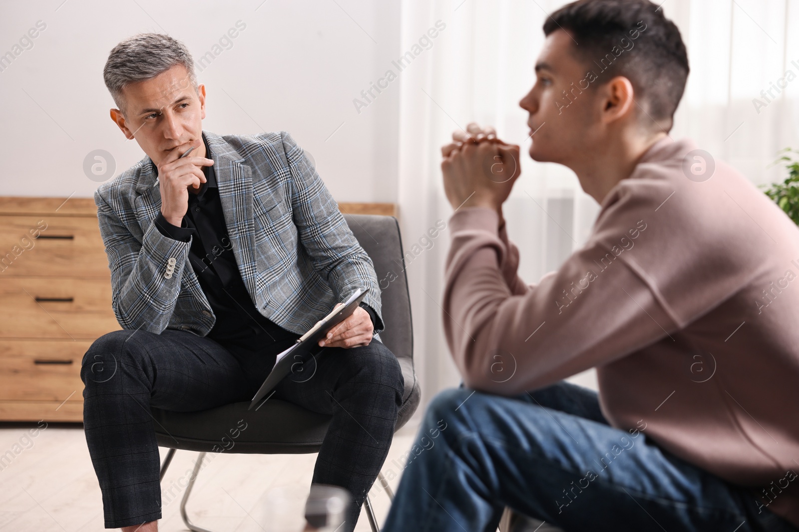 Photo of Professional psychotherapist working with patient in office