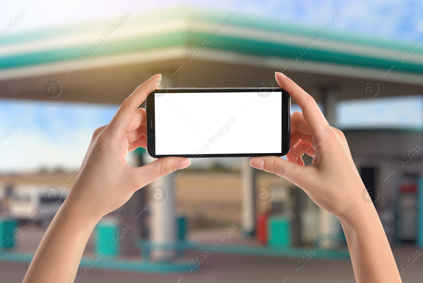 Image of Woman paying for refueling via smartphone at gas station, closeup. Device with empty screen