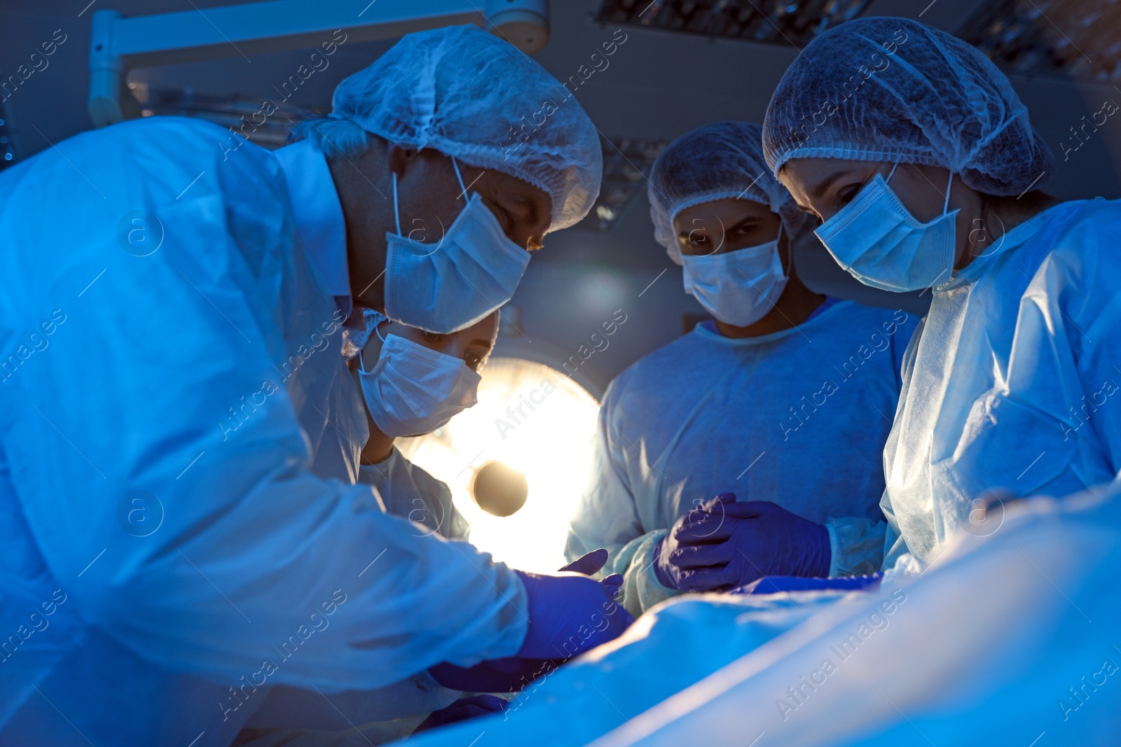 Photo of Team of professional doctors performing operation in surgery room