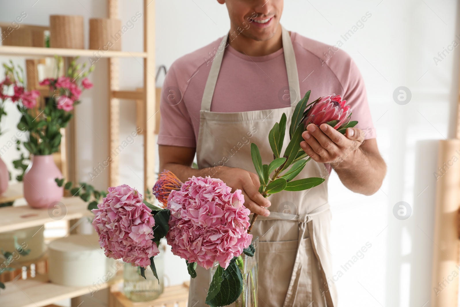 Photo of Florist with beautiful flowers in workshop, closeup