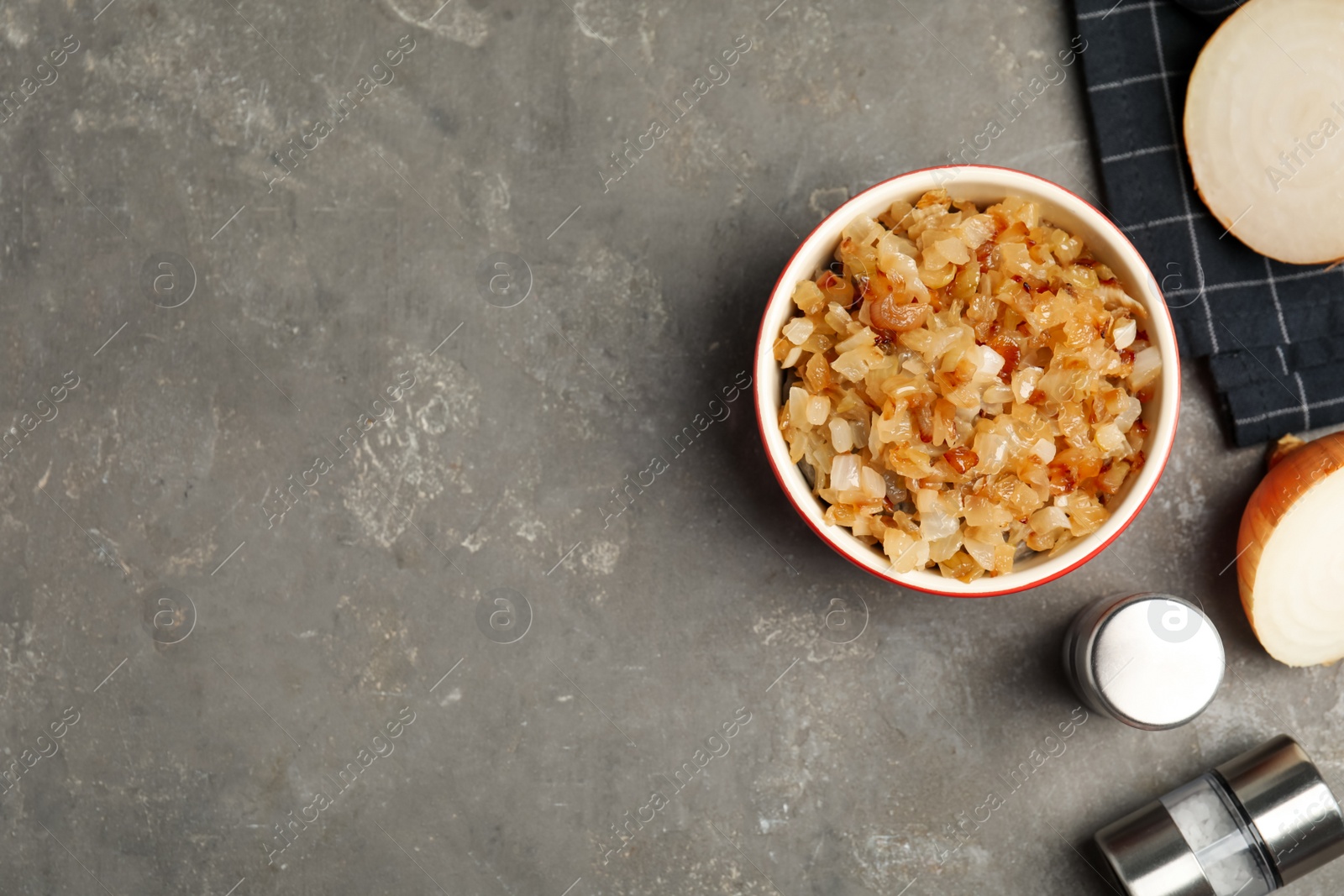 Photo of Tasty fried onion and spices on grey table, flat lay. Space for text