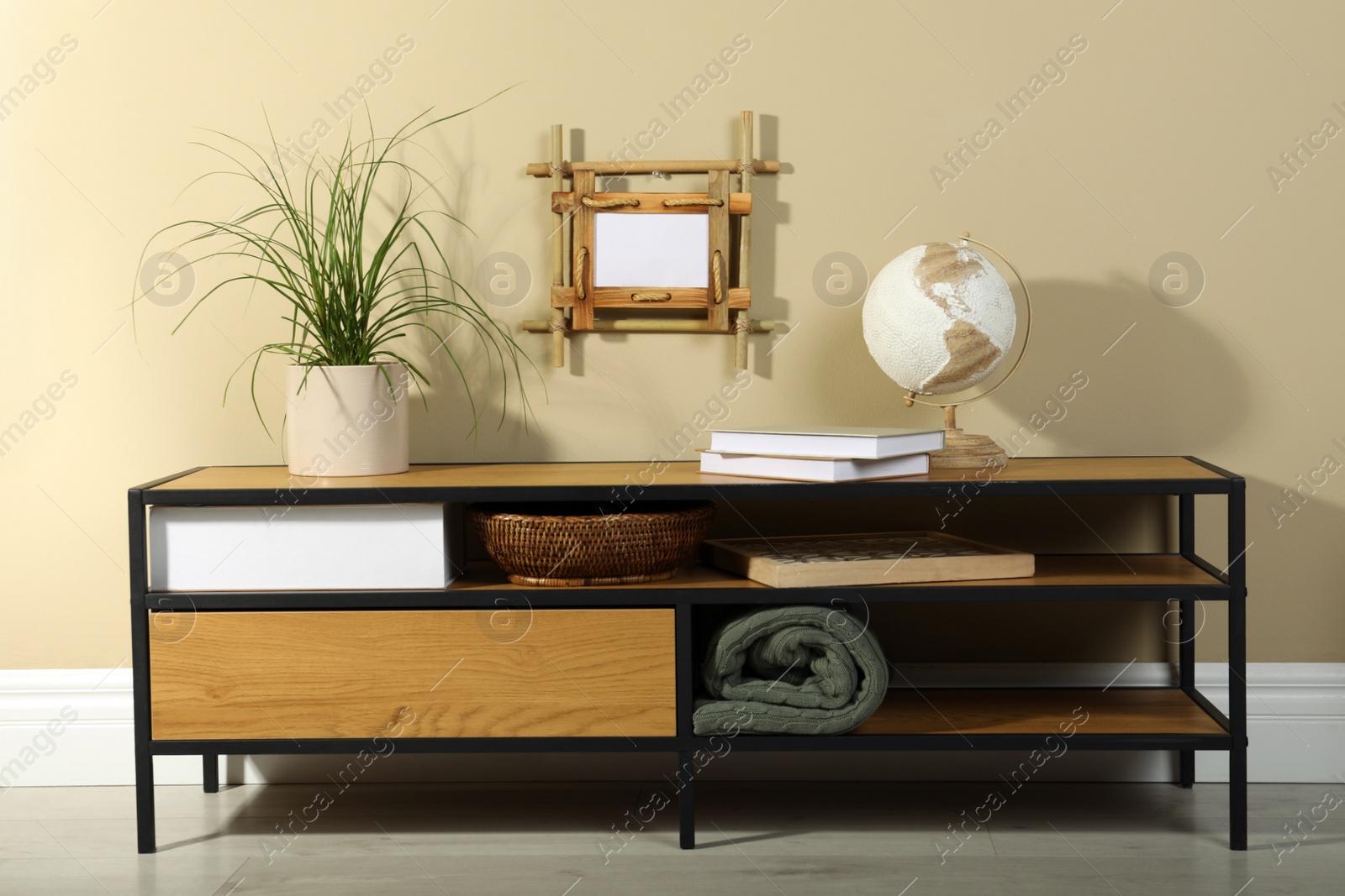 Photo of Stylish room interior with bamboo frame and wooden cabinet