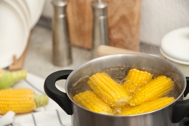 Stewpot with boiling water and corn cobs, closeup