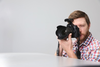 Photo of Man with professional camera in photo studio. Space for text