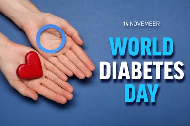 Image of World Diabetes Day. Woman holding light blue paper circle and decorative red heart on color background, top view