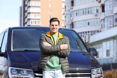 Photo of Man with key near car on city street. Buying new auto