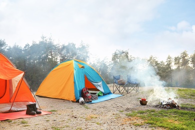 Photo of Camping tent and accessories in wilderness on summer day