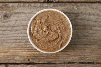 Photo of Delicious nut butter in bowl on wooden table, top view