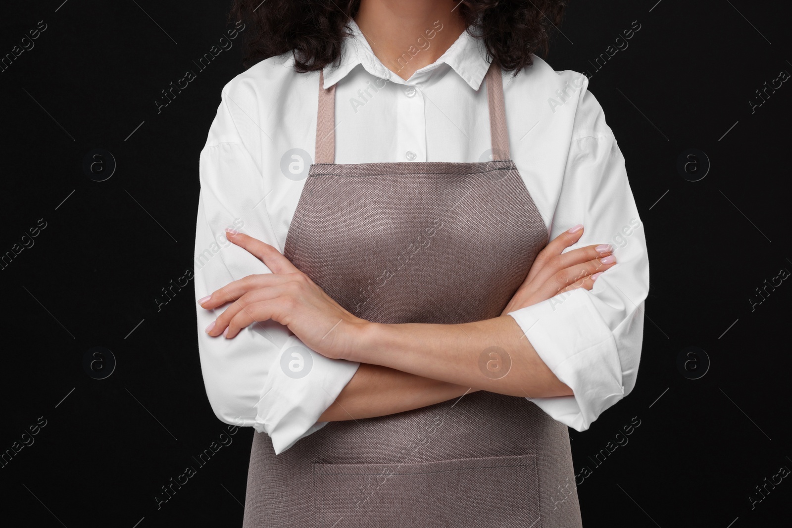 Photo of Woman wearing kitchen apron on black background, closeup. Mockup for design