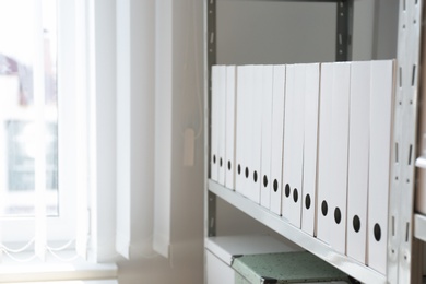 Photo of Folders with documents on shelf in archive. Space for text