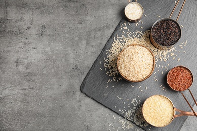 Photo of Flat lay composition with different types of rice and space for text on grey table