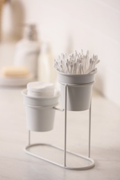 Photo of Cotton buds and pads on white table in bathroom