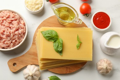 Photo of Ingredients for lasagna on white marble table, flat lay