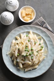 Photo of Delicious pasta with green peas, cheese and creamy sauce on grey table, top view