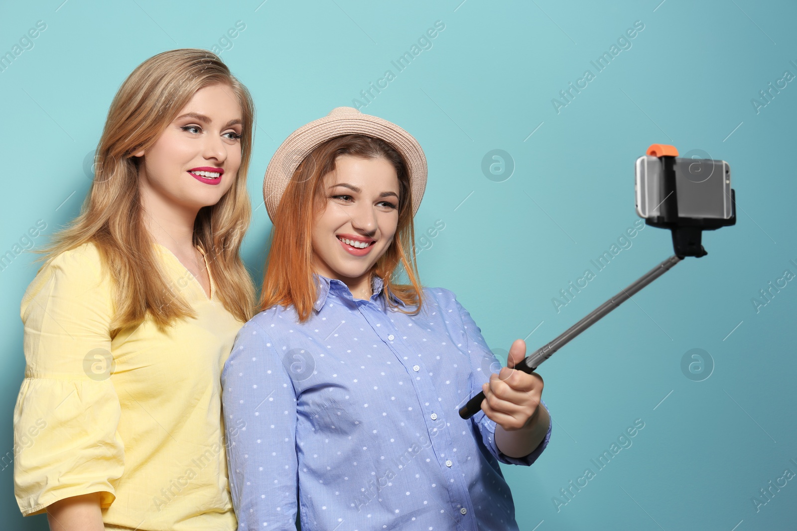 Photo of Attractive young women taking selfie on color background