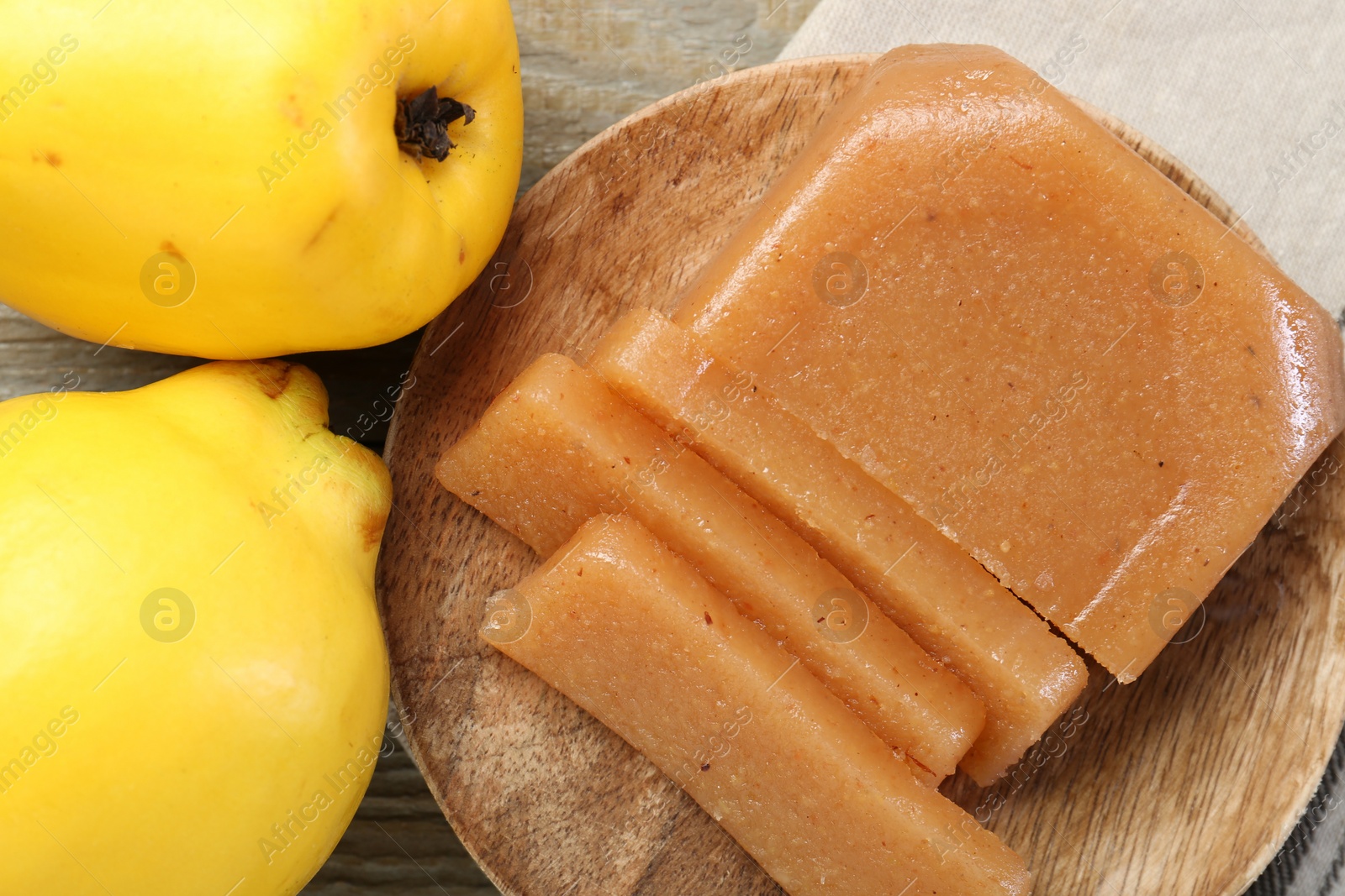 Photo of Tasty sweet quince paste and fresh fruits on wooden table, flat lay