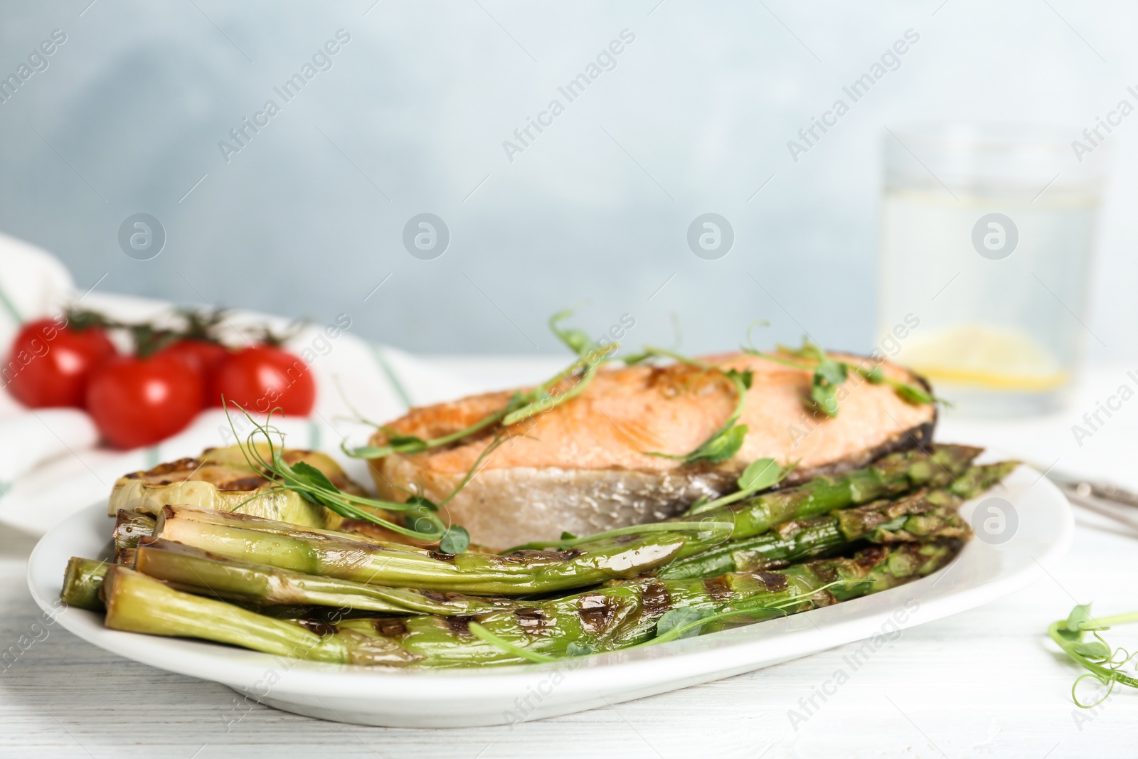 Photo of Tasty salmon steak served with grilled asparagus on plate