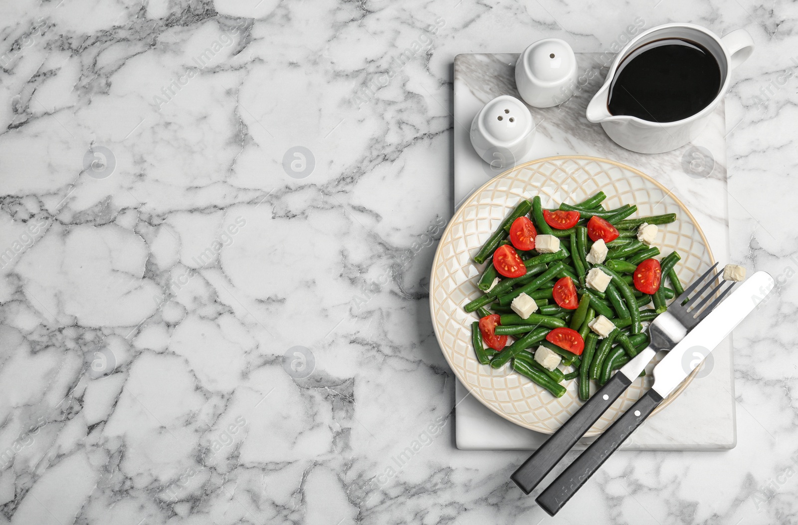 Photo of Tasty green beans with cheese and tomatoes served for dinner on marble table, top view