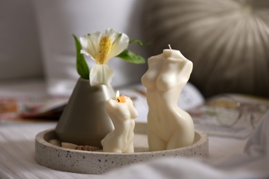 Photo of Beautiful body shaped candles and flower on bed indoors