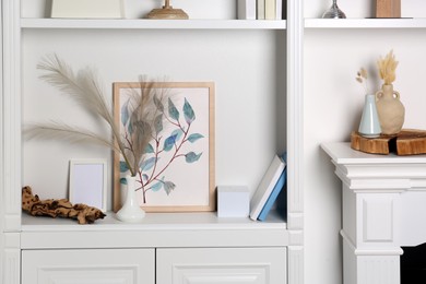 Shelving unit and fireplace with different decor indoors. Interior design