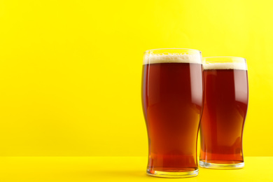 Delicious homemade kvass in glasses on yellow background. Space for text