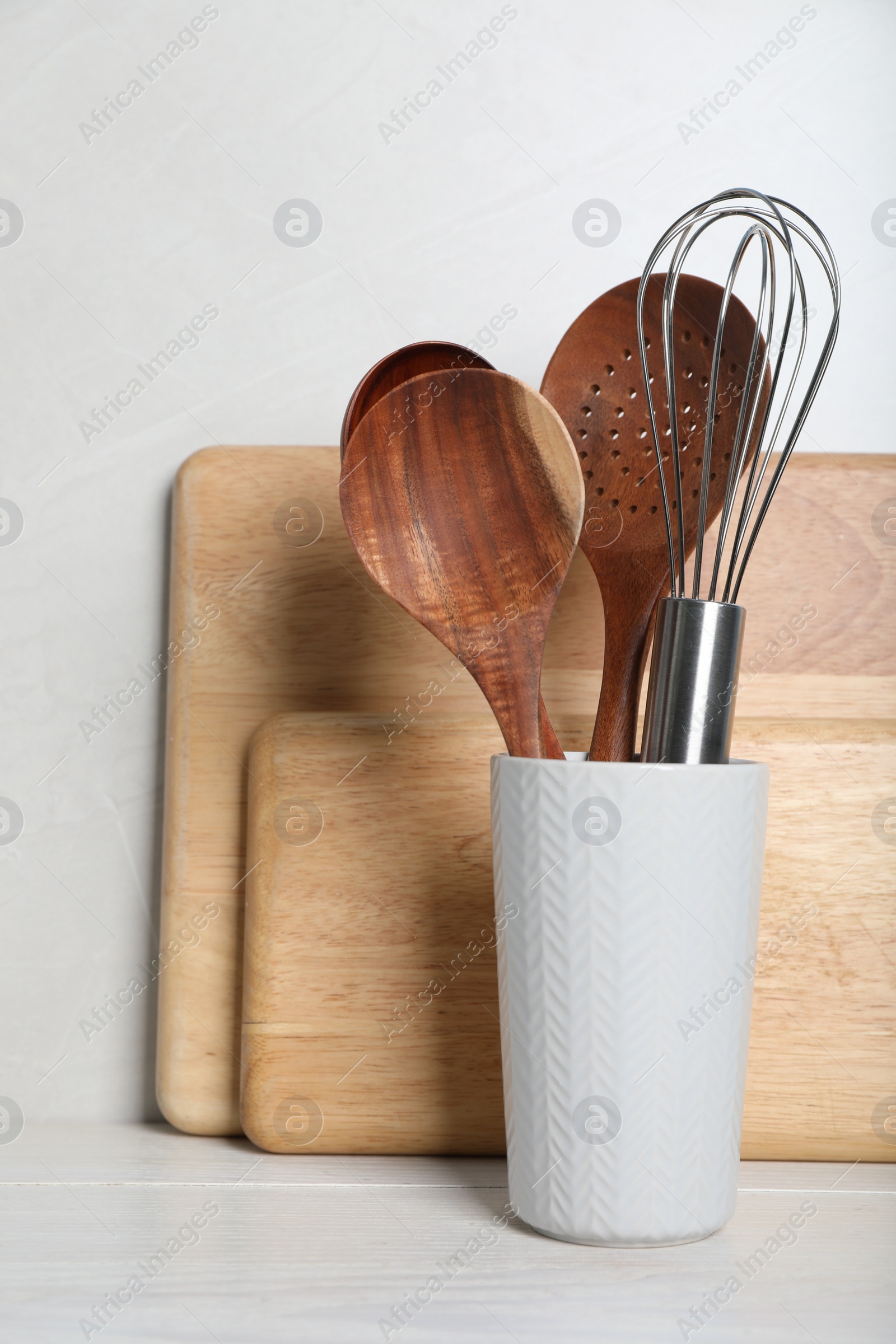 Photo of Set of kitchen utensils and boards on white wooden table