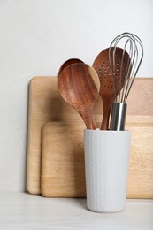 Set of kitchen utensils and boards on white wooden table