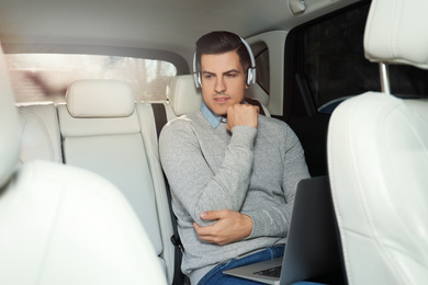 Handsome man listening to audiobook in car