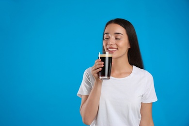 Photo of Beautiful woman with cold kvass on blue background. Traditional Russian summer drink