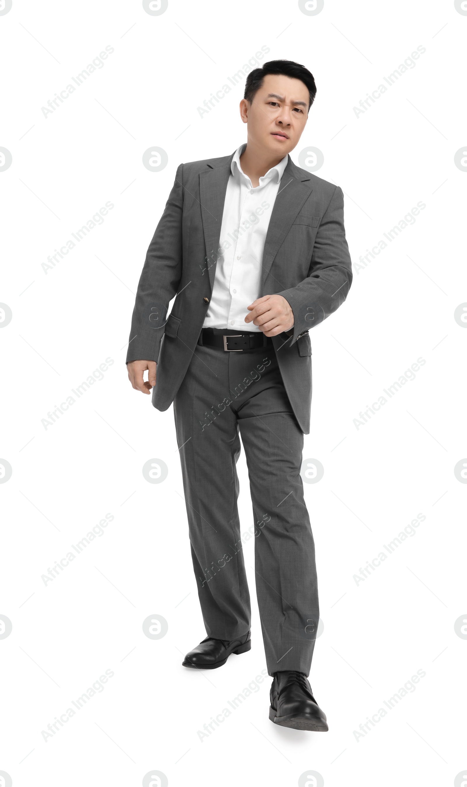 Photo of Businessman in suit walking on white background, low angle view