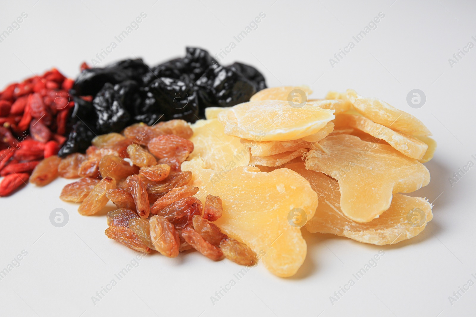 Photo of Pile of different dried fruits on white background, closeup