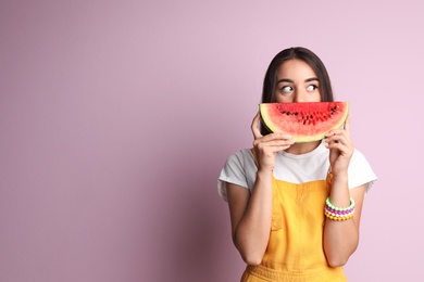 Photo of Beautiful young woman posing with watermelon on color background