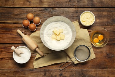 Photo of Flat lay composition with fresh butter and flour in bowl among other products on wooden table