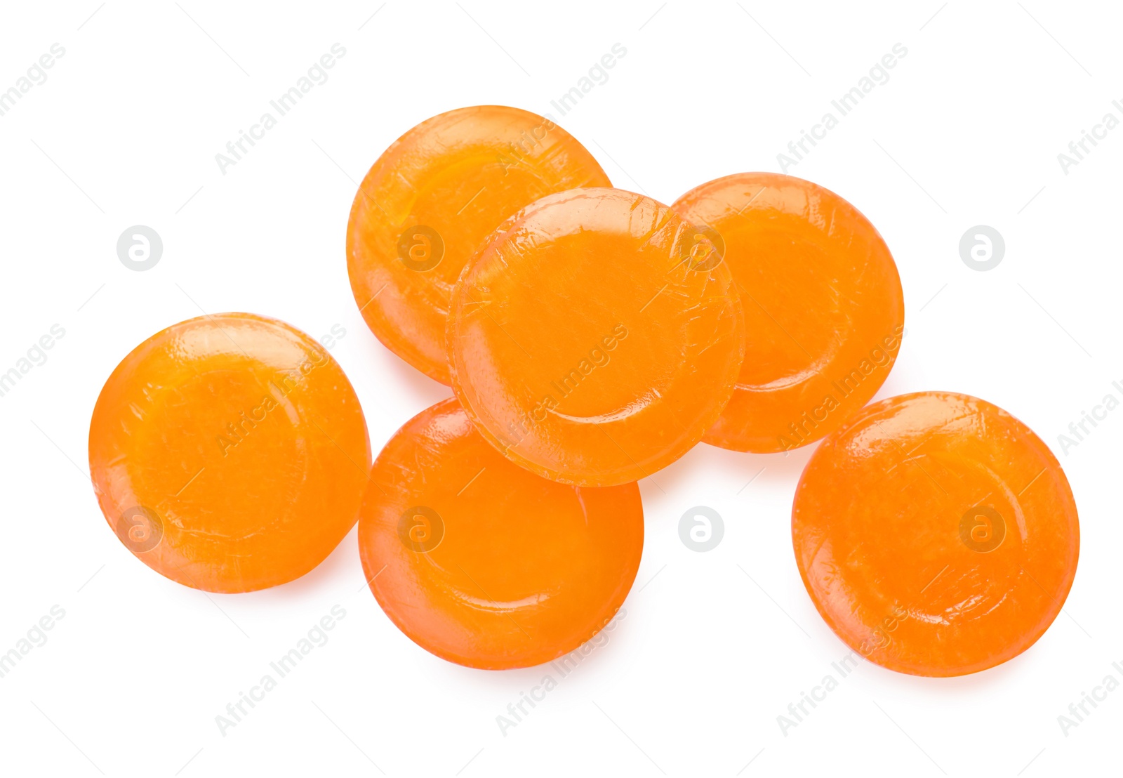 Photo of Many orange cough drops on white background, top view