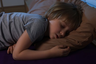 Little boy snoring while sleeping on bed at night