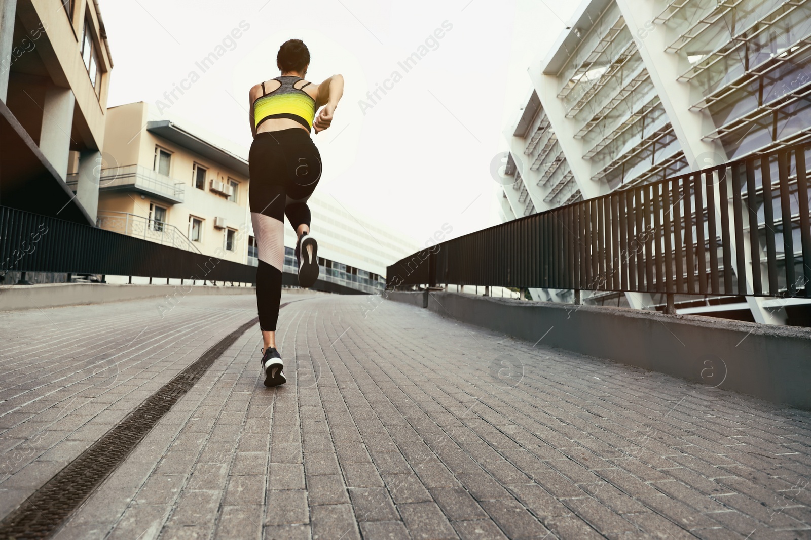 Photo of Beautiful sporty young woman running on street