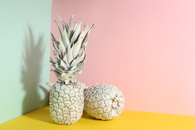 Photo of White pineapples on color background, space for text. Creative concept