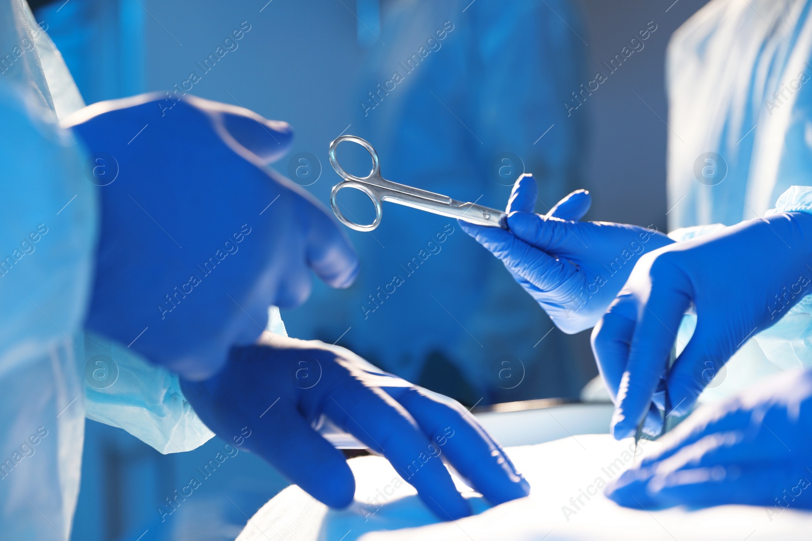 Photo of Professional surgeons performing operation in clinic, closeup