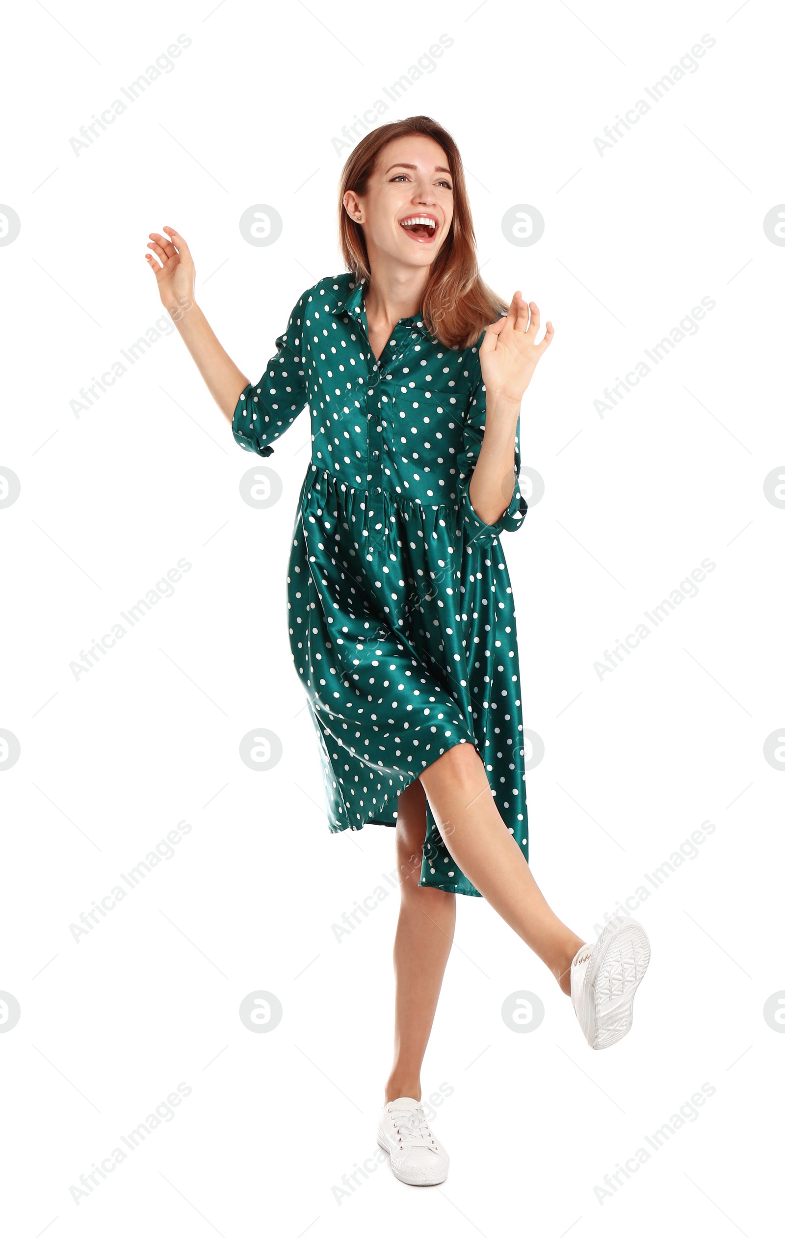 Photo of Beautiful young woman in green dress dancing on white background