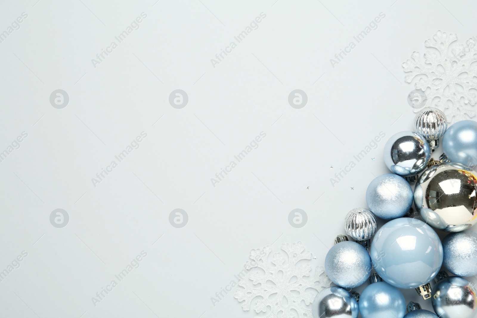 Photo of Flat lay composition with Christmas balls and decor on light background, space for text
