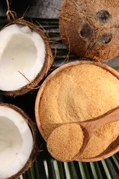 Photo of Spoon with coconut sugar, bowl and fruits on table, flat lay