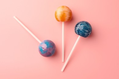 Photo of Tasty lollipops on pink background, flat lay