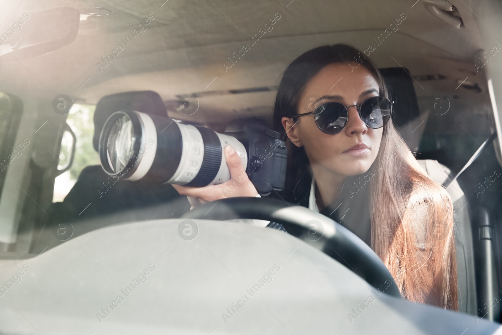 Photo of Private detective with camera spying from car