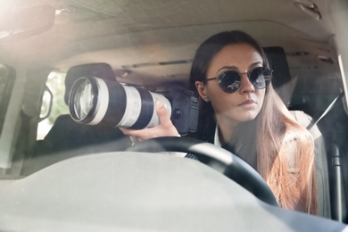 Private detective with camera spying from car