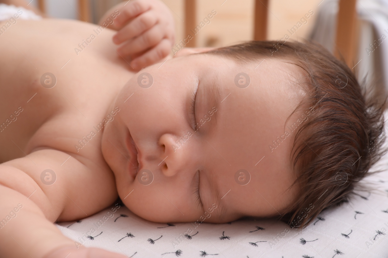 Photo of Cute little baby sleeping in crib at home, closeup