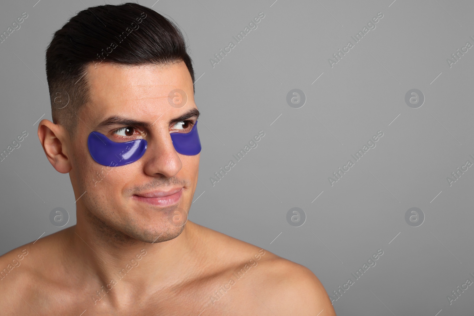 Photo of Man with blue under eye patches on grey background. Space for text