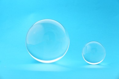 Photo of Transparent glass balls on light blue background