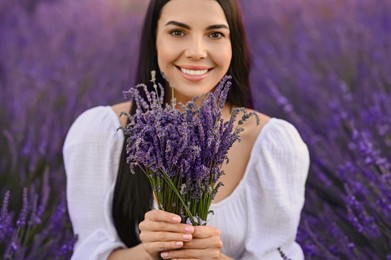 Photo of Beautiful young woman with bouquet in lavender field